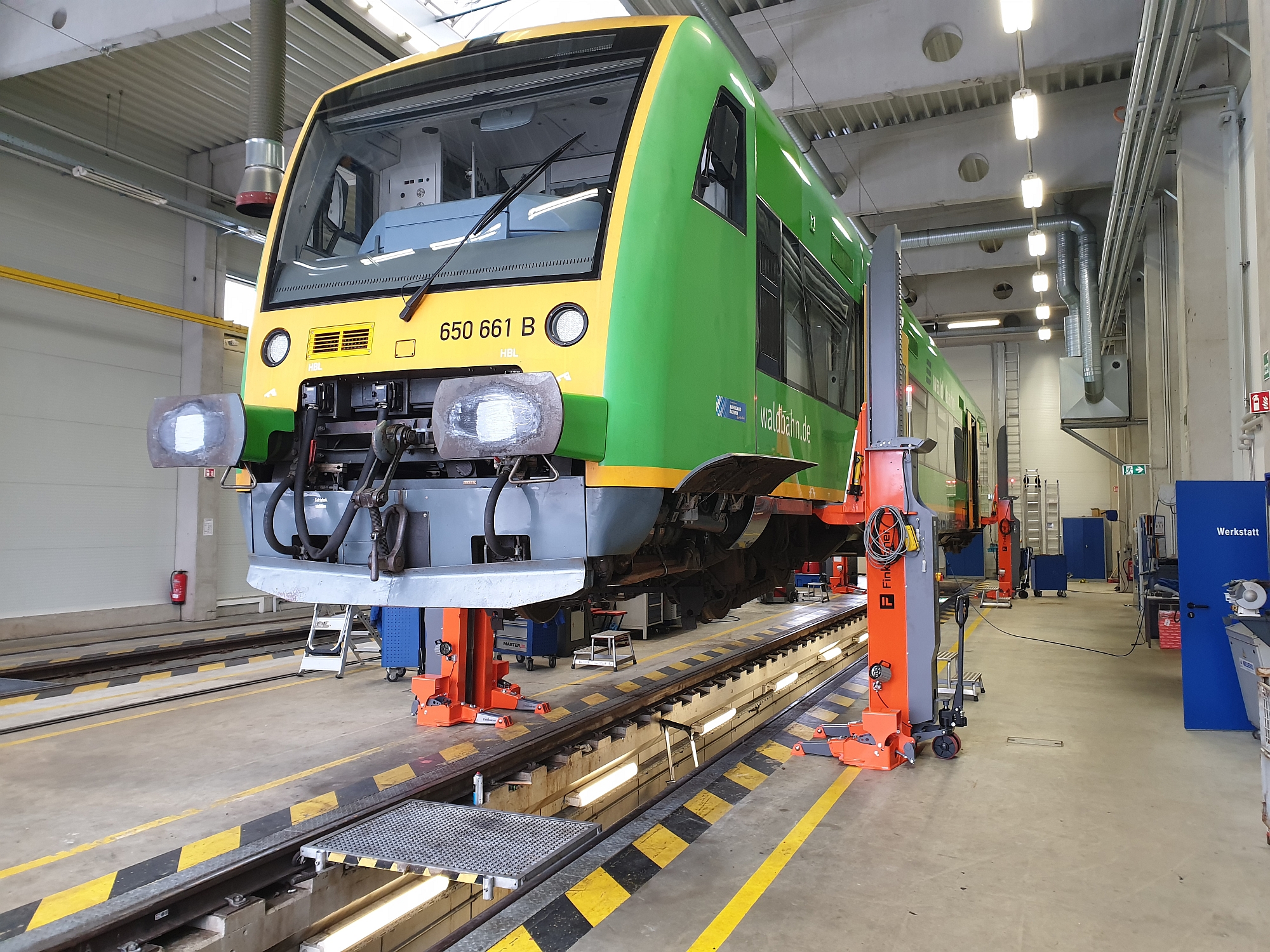 Gato elevador móvil equipado con nariz de carga ajustable en el taller ferroviario con tranvía elevado.