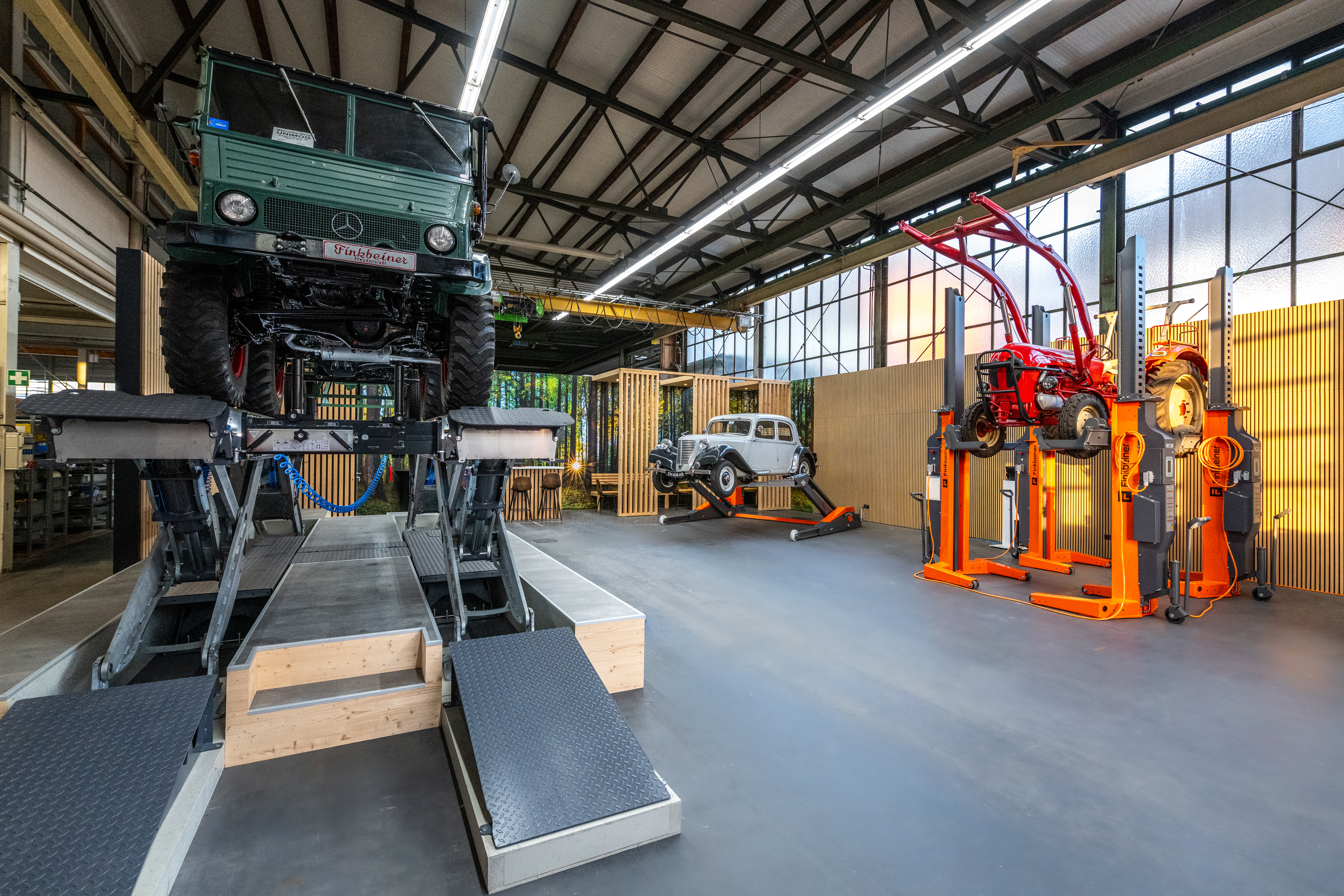 Centro de atención al cliente con coches clásicos y plataformas elevadoras